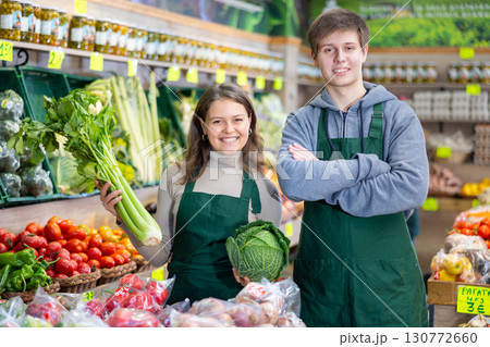 Woman and guy sellers lay out cabbage and celery 130772660