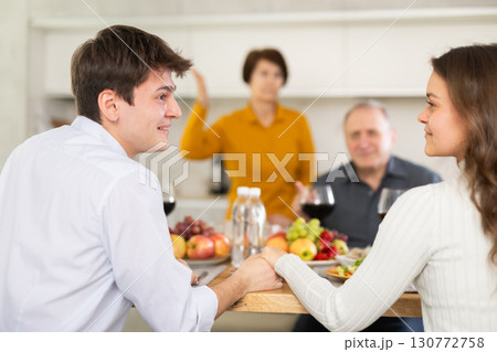 Young couple in love enjoying family dinner with elderly parents 130772758