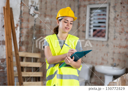 Woman taking notes on indoor construction site Woman taking notes on indoor construction site 130772829