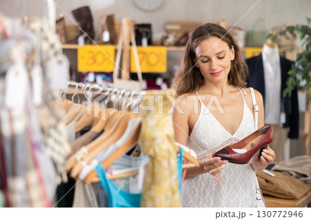Young woman choosing heels in clothing store 130772946