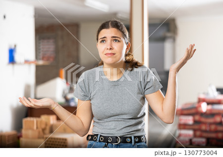 Disappointed woman standing in construction site 130773004