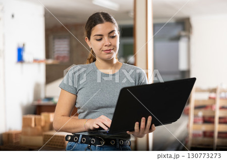 Female designer using laptop in apartment during repair works Female designer using laptop in apartment during repair works 130773273
