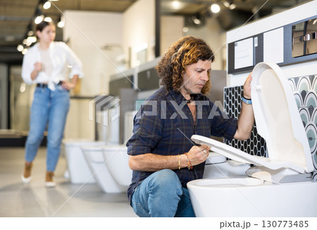 Confident man picking out new toilet in hardware store 130773485