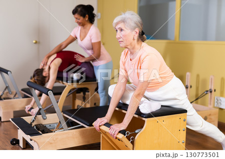 Mature woman trains on a combined chair Mature woman trains on a combined chair 130773501