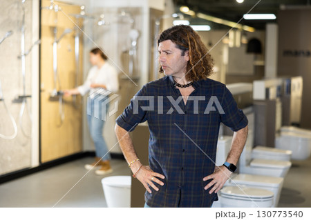 Portrait of male customer making a choice in plumbing and building materials store Portrait of male customer making a choice in plumbing and building materials store 130773540