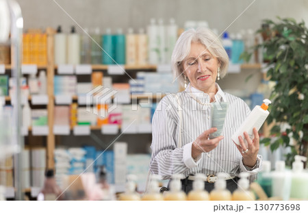 Elderly woman chooses cream at pharmacy Elderly woman chooses cream at pharmacy 130773698