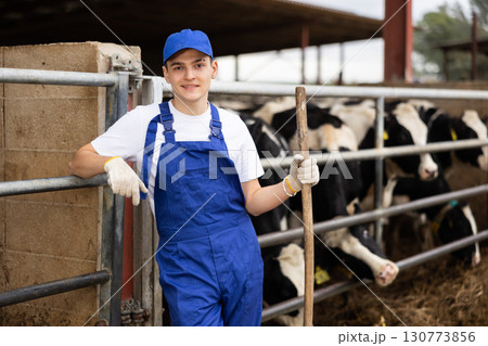 Farmer man stands with rake at cow farm Farmer man stands with rake at cow farm 130773856