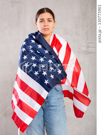 Sad young woman holding USA flag Sad young woman holding USA flag 130773901