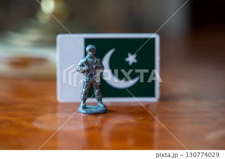 A tin soldier on the background of the flag of Pakistan. India Pakistan military conflict 130774029