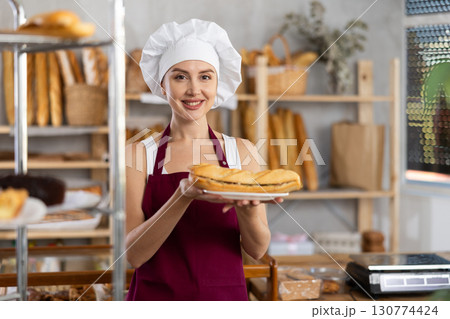 Young saleswoman holding bocadillo in disposable plate 130774424