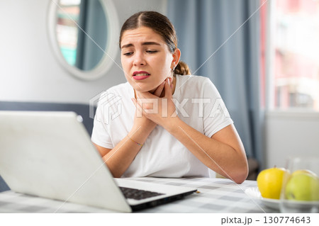Young girl tells the doctor by video link that she has a sore throat 130774643