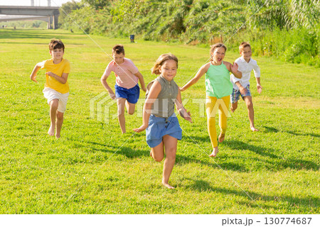 Barefoot kids running on green grass 130774687