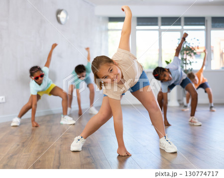 Girl performs choreographic exercises and teaches energetic mobile social dance hip hop with friends Girl performs choreographic exercises and teaches energetic mobile social dance hip hop with friends 130774717