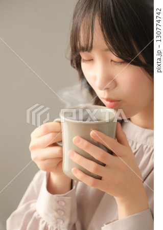 ホットな飲み物を飲む若い女性 130774742
