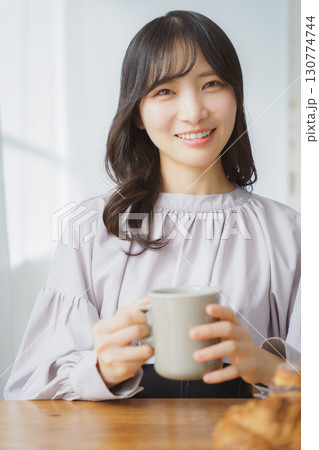 ホットな飲み物を飲む若い女性 ホットな飲み物を飲む若い女性 130774744