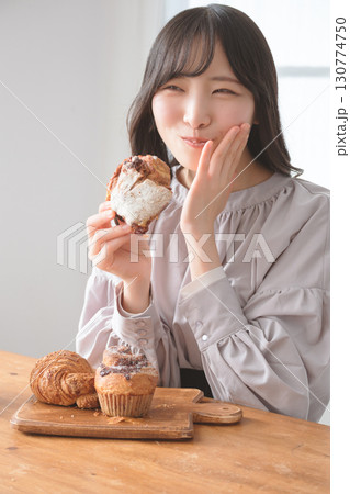 美味しそうにマフィンを食べる若い女性 130774750