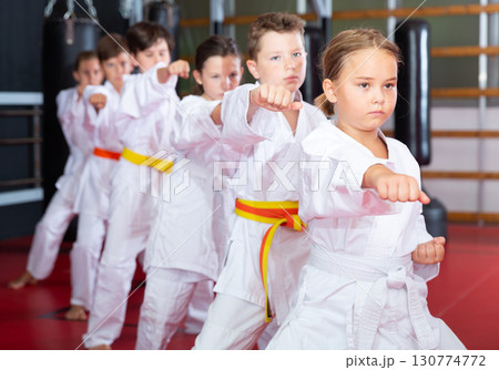 Karate kids in kimono performing kata moves 130774772