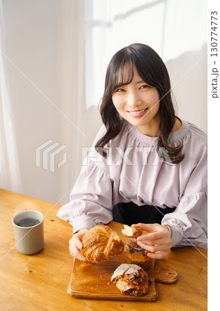 美味しそうにマフィンを食べる若い女性 美味しそうにマフィンを食べる若い女性 130774773