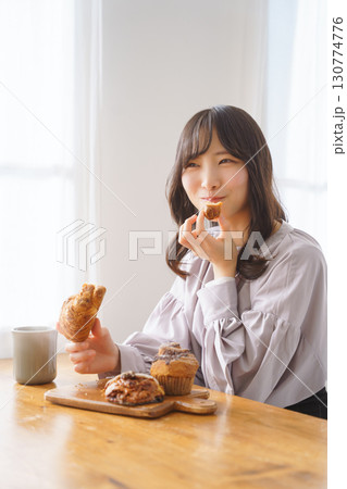 美味しそうにマフィンを食べる若い女性 130774776