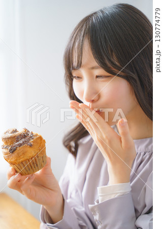 美味しそうにマフィンを食べる若い女性 130774779