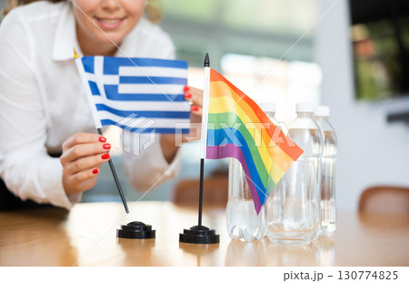 Unrecognizable girl sets midget flags of Greece and LGBT before international negotiations 130774825