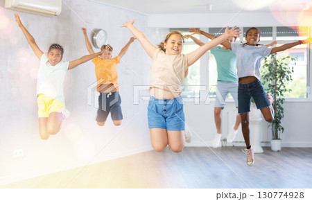 Children jumping while studying modern style dance in class indoors Children jumping while studying modern style dance in class indoors 130774928