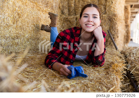 Happy girl resting after hard work in hayloft 130775026