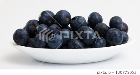 Bowl of blueberries on white surface 130775053