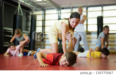 Girl practice self-defense techniques on trainer 130775067