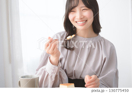 美味しそうにケーキを食べる若い女性 130775450