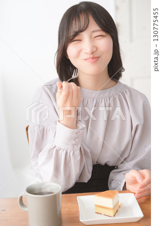 美味しそうにケーキを食べる若い女性 130775455