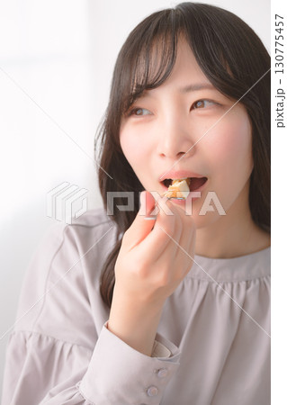 美味しそうにケーキを食べる若い女性 130775457
