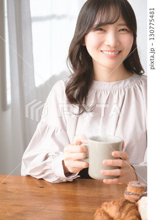 ホットな飲み物を飲む若い女性 ホットな飲み物を飲む若い女性 130775481