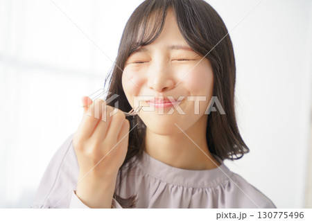 美味しそうにケーキを食べる若い女性 130775496
