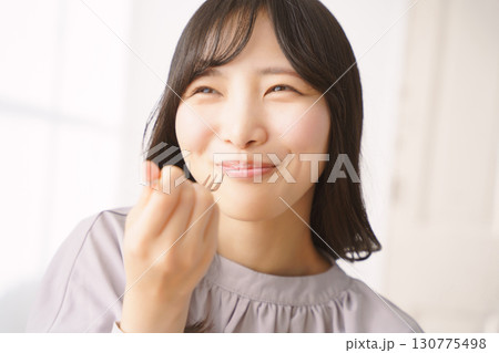 美味しそうにケーキを食べる若い女性 130775498