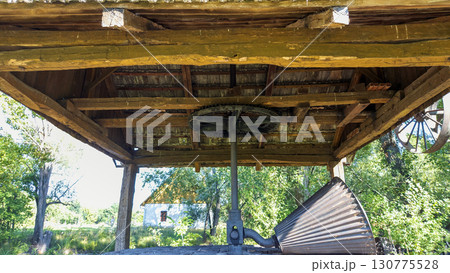 Antique shredder, branch crusher under a wooden roof in Slovakia. In working condition. Close-up. 130775528