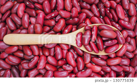 Close-up of red kidney beans in a wooden spoon with beans spread in the background, symbolizing healthy food, agriculture, and plant-based protein. Close-up of red kidney beans in a wooden spoon with beans spread in the background, symbolizing healthy food, agriculture, and plant-based protein. 130775839