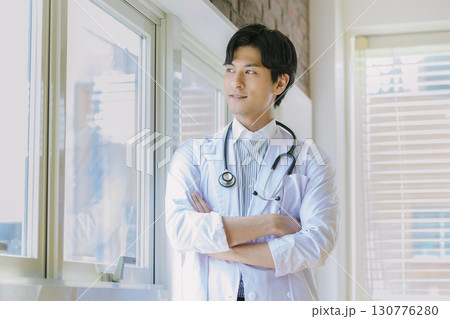 窓辺に立つ白衣を着た若い医師 窓辺に立つ白衣を着た若い医師 130776280