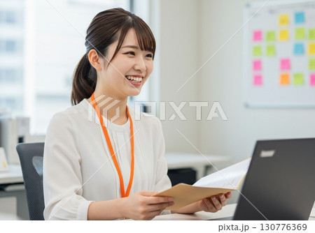 オフィスで笑顔の女性社員|書類・パソコン業務・ビジネスシーンに活用できるフリー素材写真 オフィスで笑顔の女性社員|書類・パソコン業務・ビジネスシーンに活用できるフリー素材写真 130776369