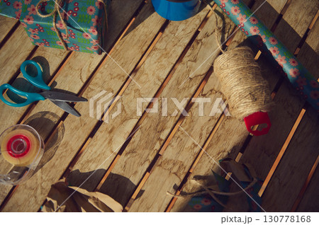 Wooden Table with Gift Wrapping Supplies in Warm Lighting 130778168