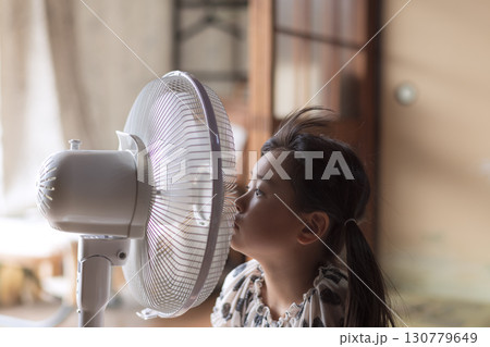 扇風機の風にあたる夏休みの子供 130779649