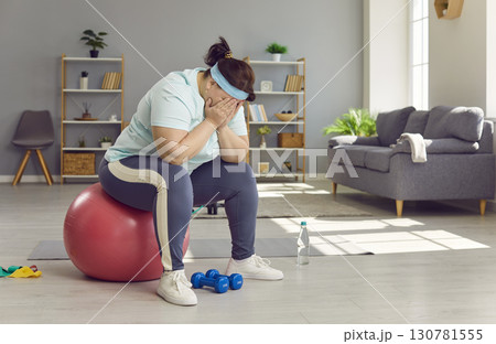 Fat woman who can't lose weight despite sports workouts is sitting on fit ball and crying Fat woman who can't lose weight despite sports workouts is sitting on fit ball and crying 130781555