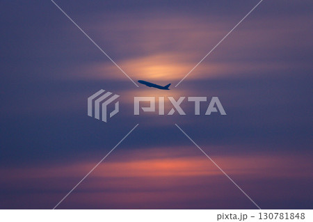 夕焼け空を飛ぶ飛行機の美しいシルエット 夕焼け空を飛ぶ飛行機の美しいシルエット 130781848