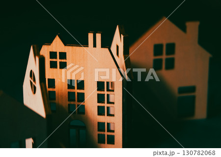 Miniature wooden houses, beautifully crafted and arranged in a row, perfect for home and real estate concepts. Houses have intricate window cutouts. Miniature wooden houses, beautifully crafted and arranged in a row, perfect for home and real estate concepts. Houses have intricate window cutouts. 130782068