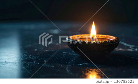Single Clay Diya on Black Marble Surface. Diwali Festival Concept. Generated Image Single Clay Diya on Black Marble Surface. Diwali Festival Concept. Generated Image 130782523