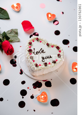 Romantic heart shaped cake with roses and candles for Valentines Day celebration Romantic heart shaped cake with roses and candles for Valentines Day celebration 130782861