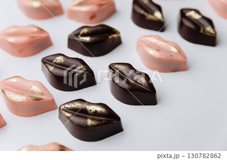Luxury lip shaped chocolate candies with gold decor on pastel background Luxury lip shaped chocolate candies with gold decor on pastel background 130782862