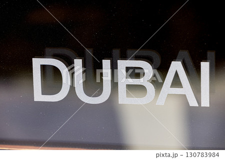 The inscription on slightly dusty transparent glass reads the word DUBAI  130783984