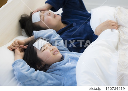 熱を出した小学生の女の子とお母さん　 130784419