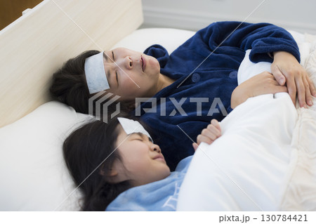 熱を出した小学生の女の子とお母さん　 130784421